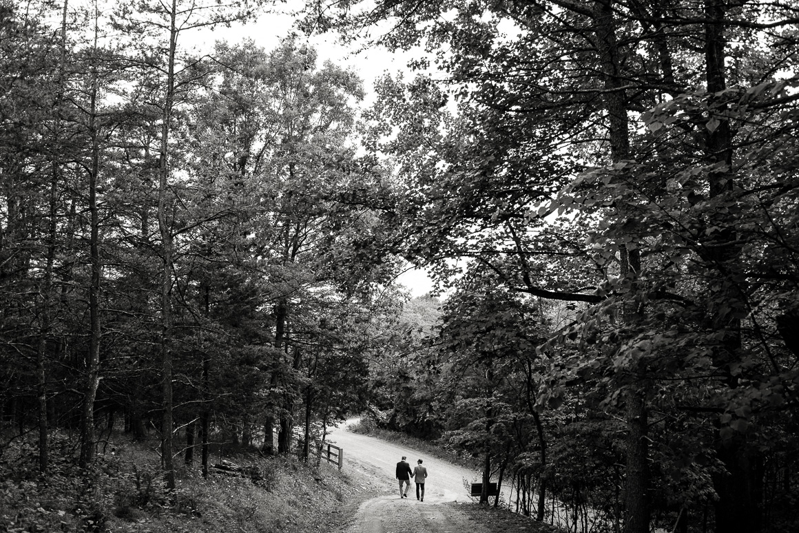 West Virginia Gay wedding couple take path through woods.