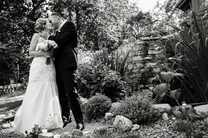 Denver wedding photojournalist captures ceremony kiss in backyard wedding.