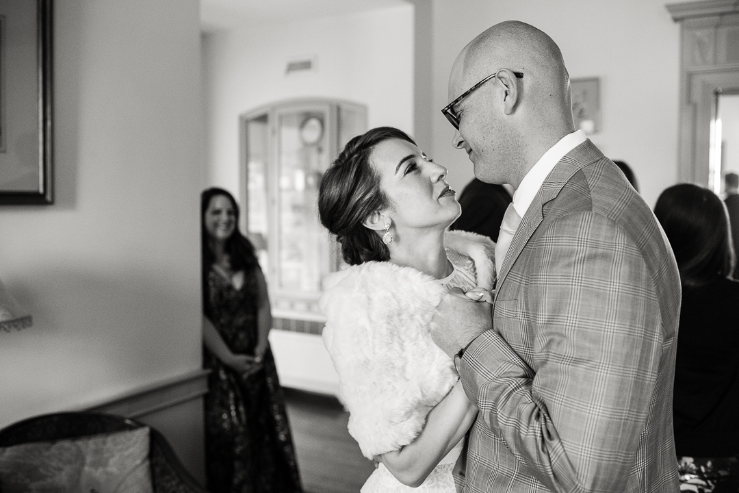 bride and groom have a quiet moment amidst the crowd during cocktail hour