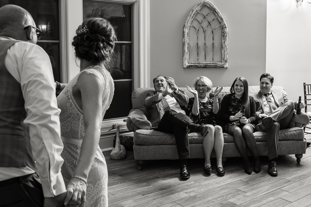 wedding guests on couch cheer for bride and groom