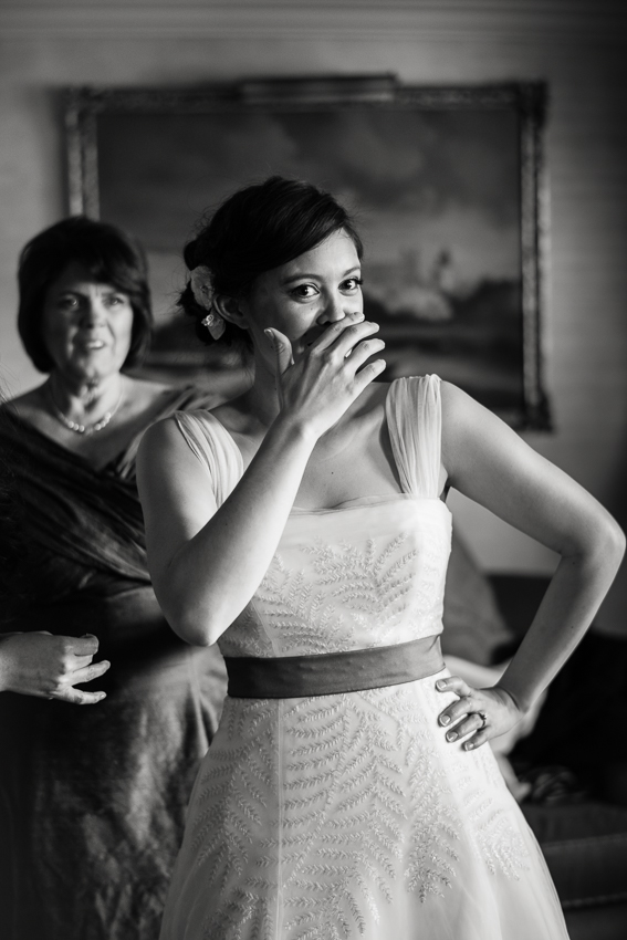 Bride laughs in wedding dress in the Presidential suite at the Denver Warwick Hotel.
