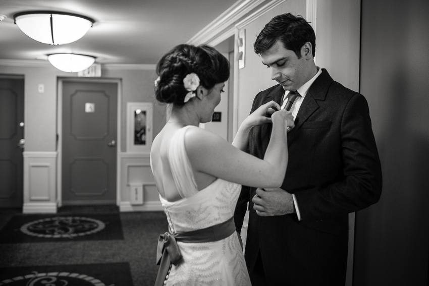 Bride adjusts grooms tie near the elevators of the Denver Warwick Hotel.