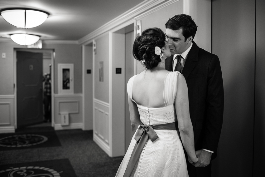 Bride kisses groom in the hallway of the Denver Warwick Hotel.