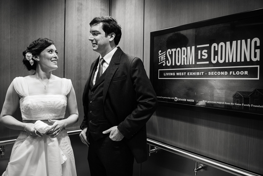 Bride and groom ignore the omens in the elevator at the History Center Colorado by Denver wedding photojournalist.