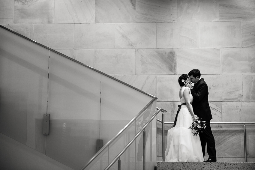Denver wedding photojournalist captures kiss on the large stairwell of the History Center Colorado.