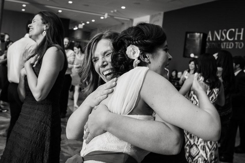 Denver wedding photojournalist captures bride and friend laughing on the dance floor.