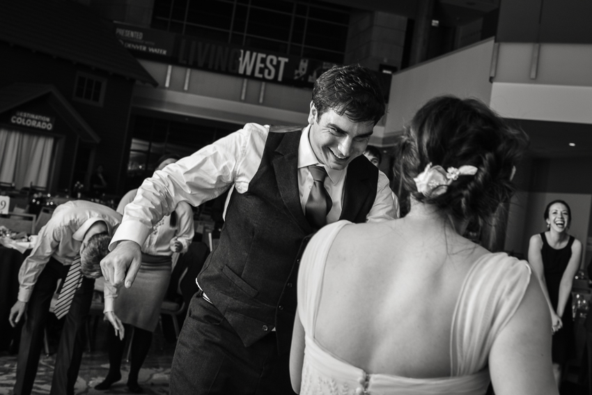 Groom approaches bride on the dance floor of a History Center Colorado wedding by Denver wedding photojournalist.