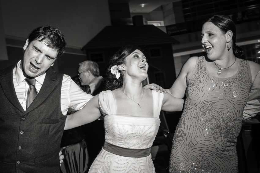 Groom, bride, and guest on the dance floor by Denver wedding photojournalist.
