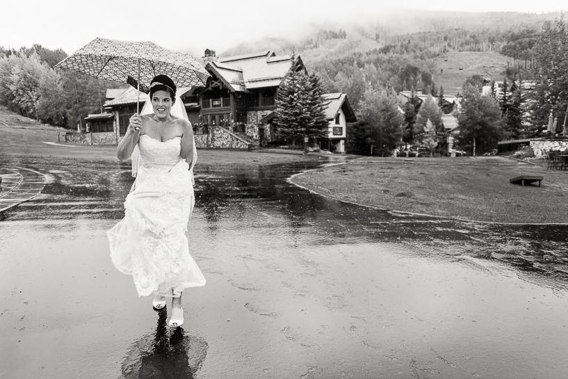 Bride at a Beaver Creek wedding makes her way through the rain to the gondola.