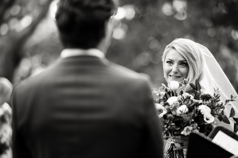 Image of bride during a wedding ceremony, over the shoulder of the groom by Denver wedding photojournalist at The Villa Parker.