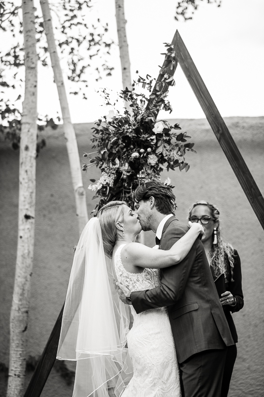 Bride and groom kiss at the conclusion of a ceremony by Denver wedding photojournalist at The Villa Parker.