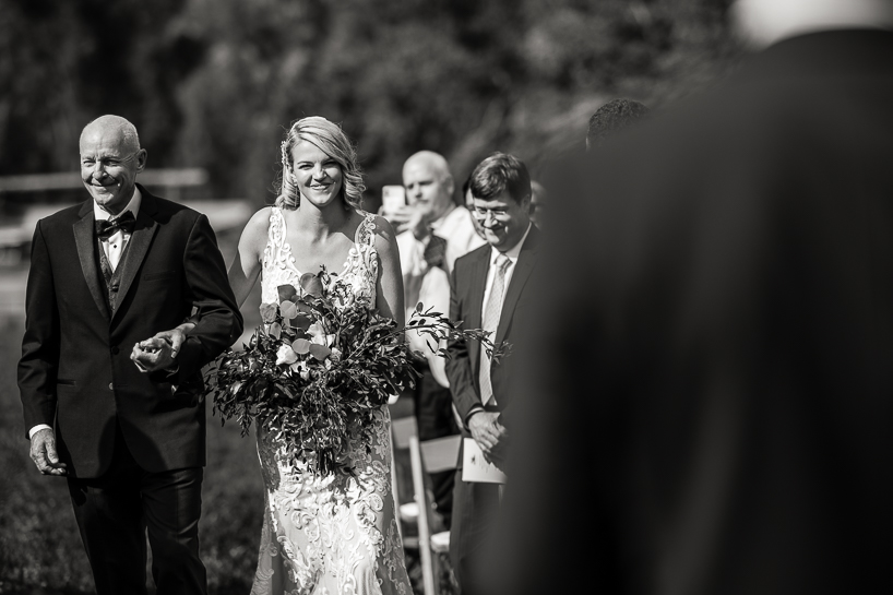 Bride's father walks her down the aisle during an Aspen wedding ceremony.