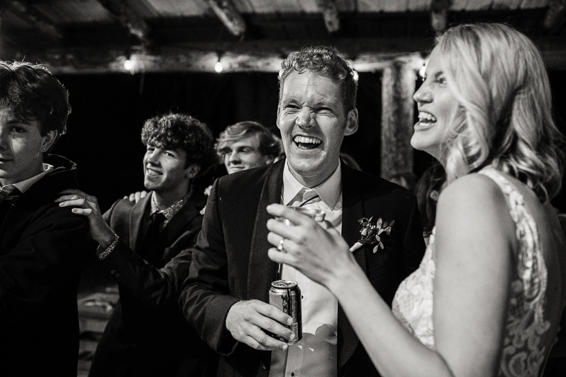 Wedding couple laughing at reception.