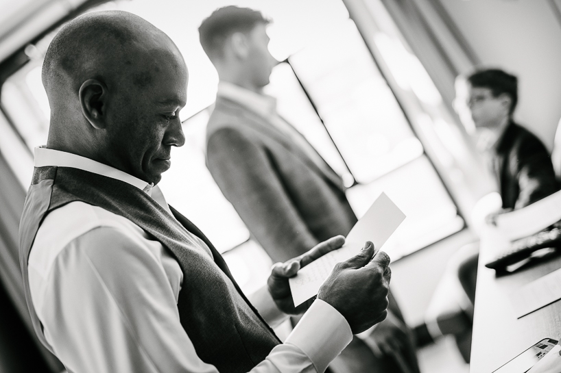 Groom reads a note from his bride while getting ready for a Ramble Hotel Wedding in Denver.