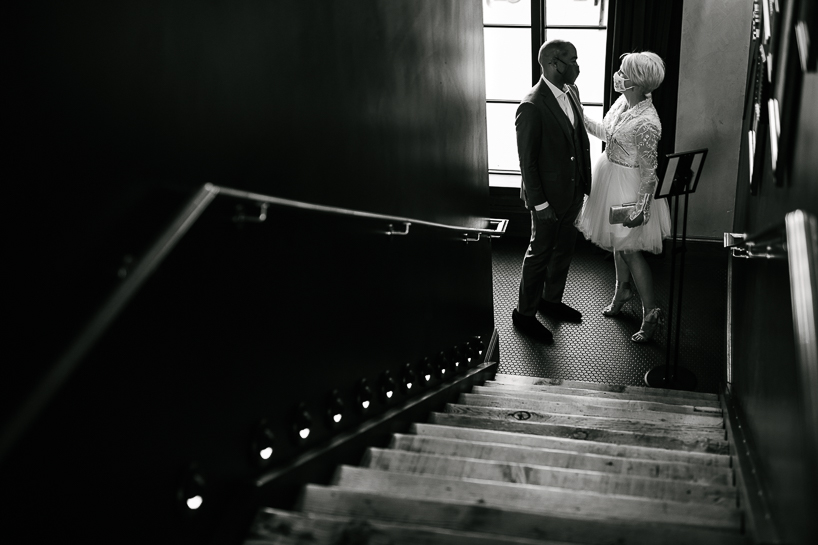 Bride and groom share a moment at the bottom of a staircase in The Ramble Hotel in Denver.