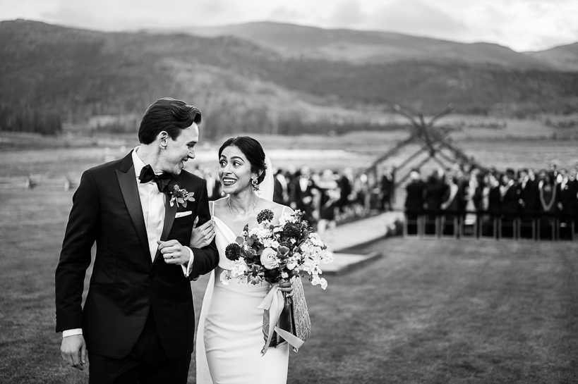In a Rocky Mountain wedding outside Winter Park, Colorado, a bride and groom gaze at each other after leaving their outdoor wedding ceremony at Devil's Thumb Ranch.