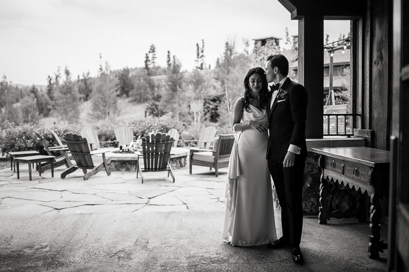Black and white image of a bride and groom on an outdoor patio sharing a quiet moment after their Devil's Thumb Ranch wedding.