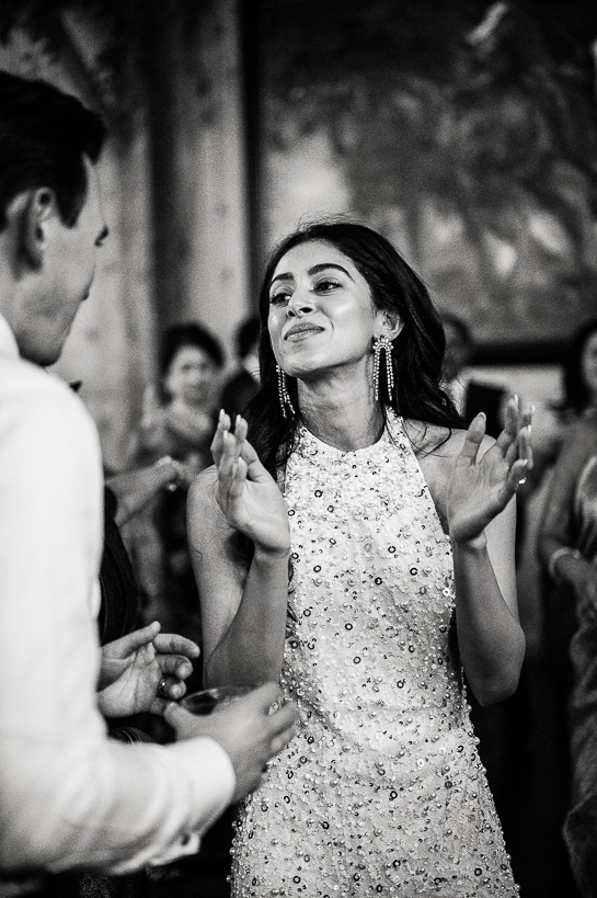 Bride in sequined dress dancing during a Winter Park wedding reception with her groom in black and white photograph.