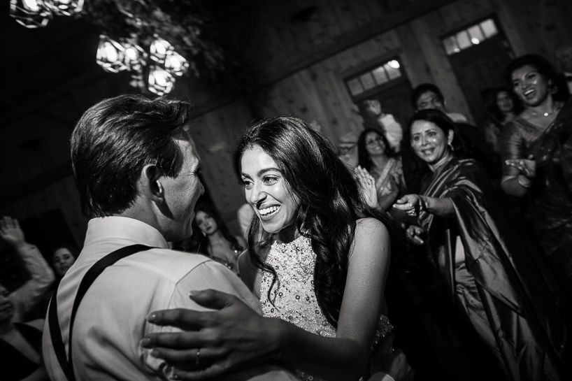 Authentic wedding photo of bride and groom on the dance floor in dramatic black and white.