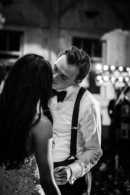 Bride and groom kiss on the dance floor in an available light black and white photograph from a Devil's Thumb Ranch wedding.